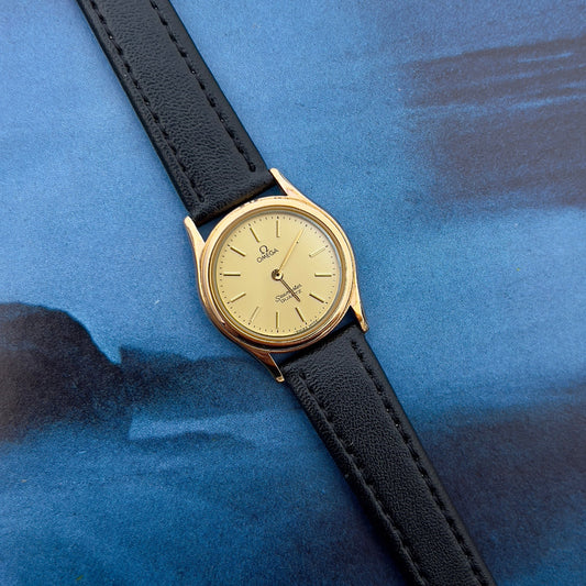 Omega Seamaster gold-tone women's watch with champagne dial.