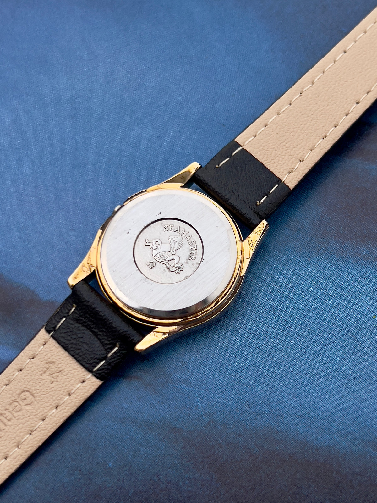Aftermarket strap detail on the Omega Seamaster watch.
