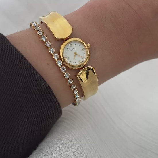 Vintage Citizen Chère women’s gold bangle watch with white dial and Roman numeral, styled on wrist with a crystal tennis bracelet