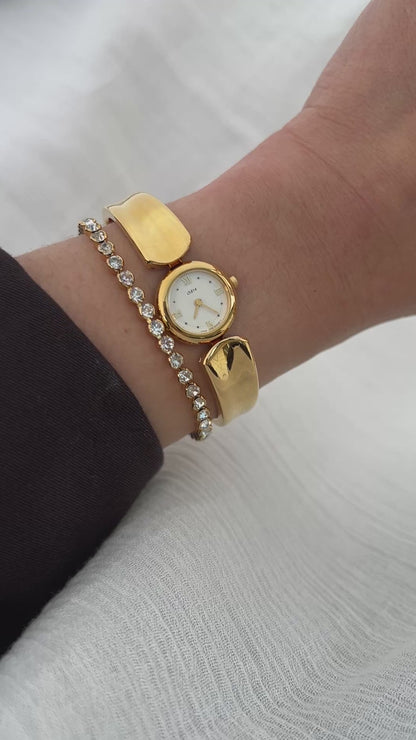 Vintage Citizen Chère women’s gold bangle watch with white dial and Roman numeral, styled on wrist with a crystal tennis bracelet