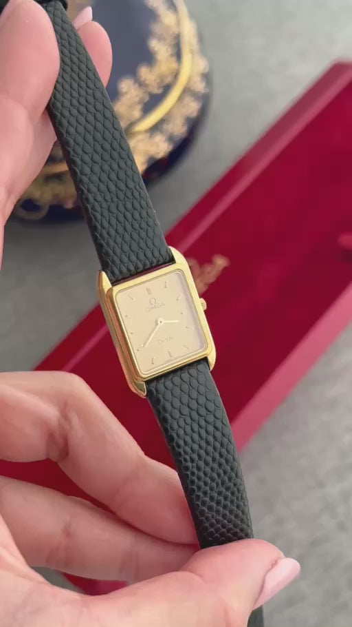 Close-up video of the Omega De Ville champagne dial gold watch with black textured strap, showing the dial, case and strap details.