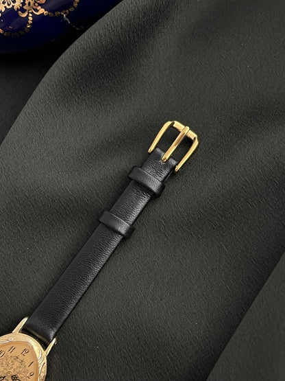 Gold-tone buckle and black leather strap detail on the Seiko 1E20-0370 watch