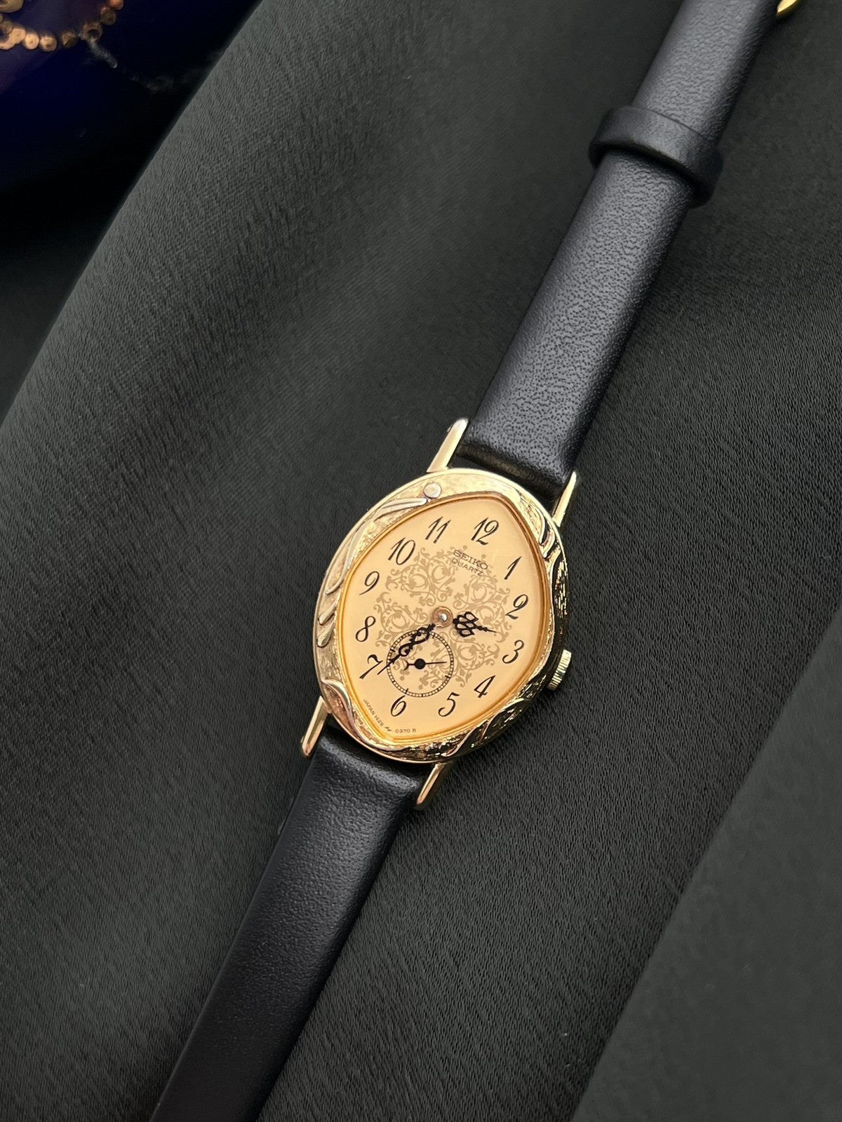 Close view of the Seiko 1E20-0370 champagne dial with ornate central motif and gold-tone case