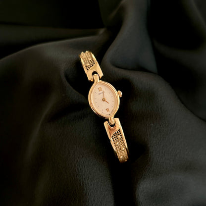 Seiko petite gold-tone oval quartz watch with textured bracelet, full front view