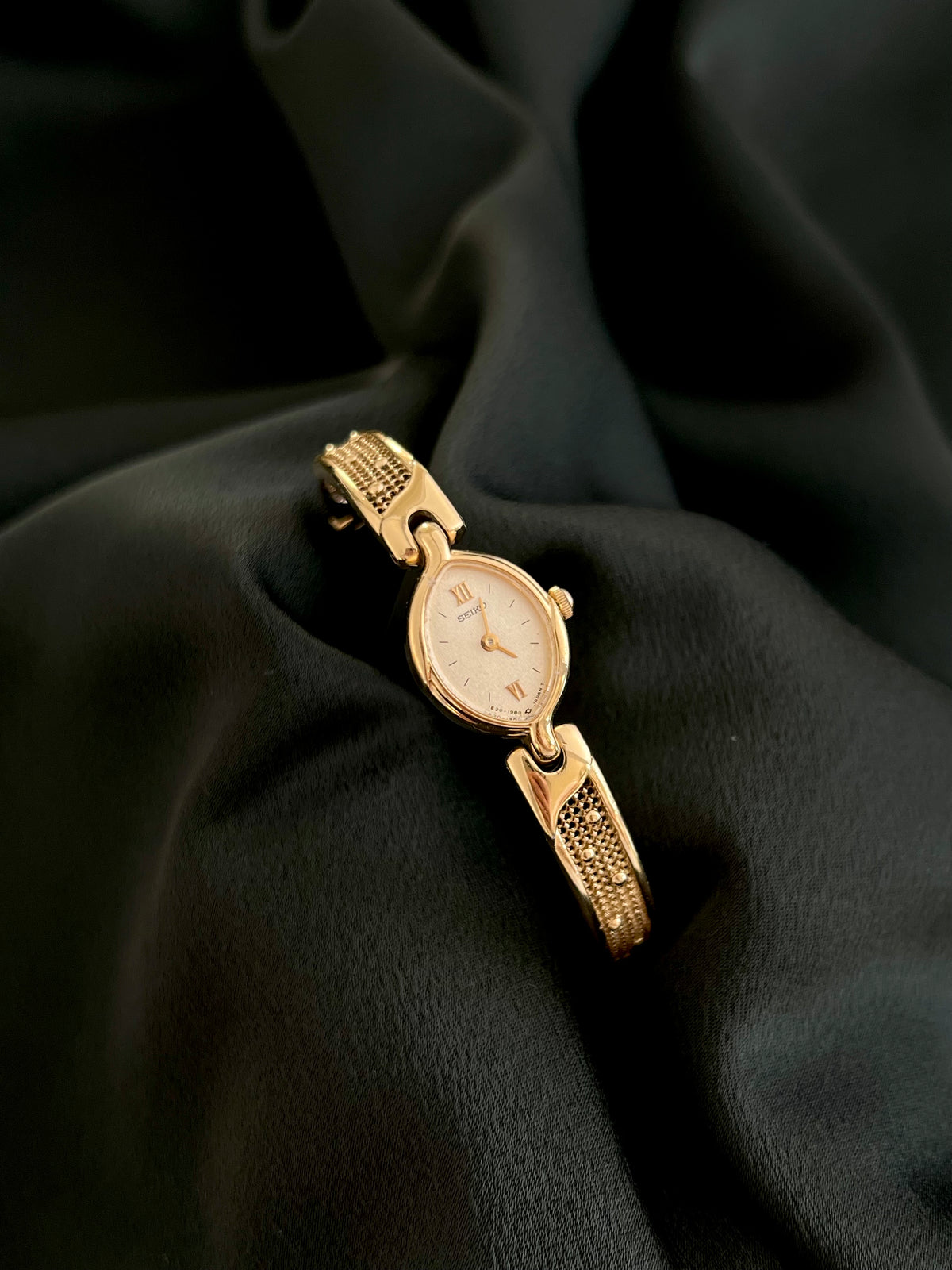 Seiko gold-tone oval watch worn on wrist