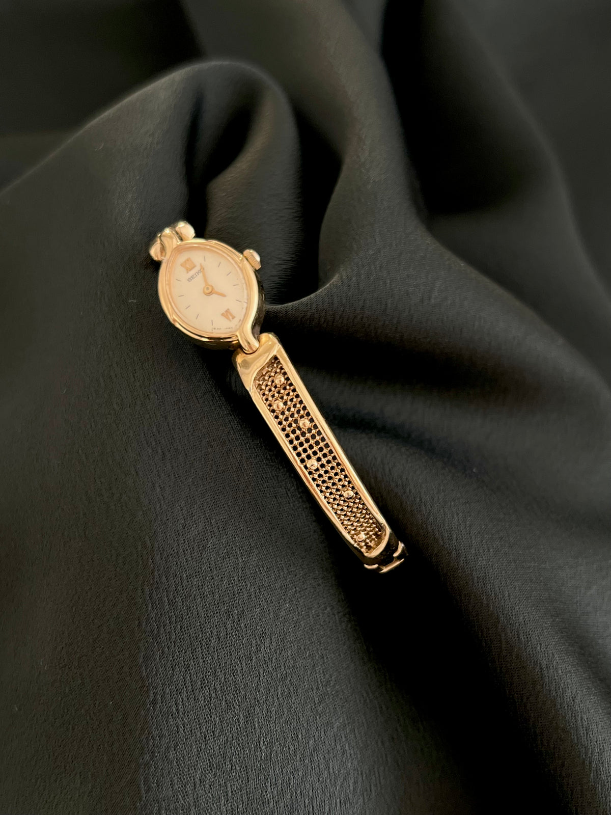 Angled full view of Seiko gold-tone watch and textured bracelet