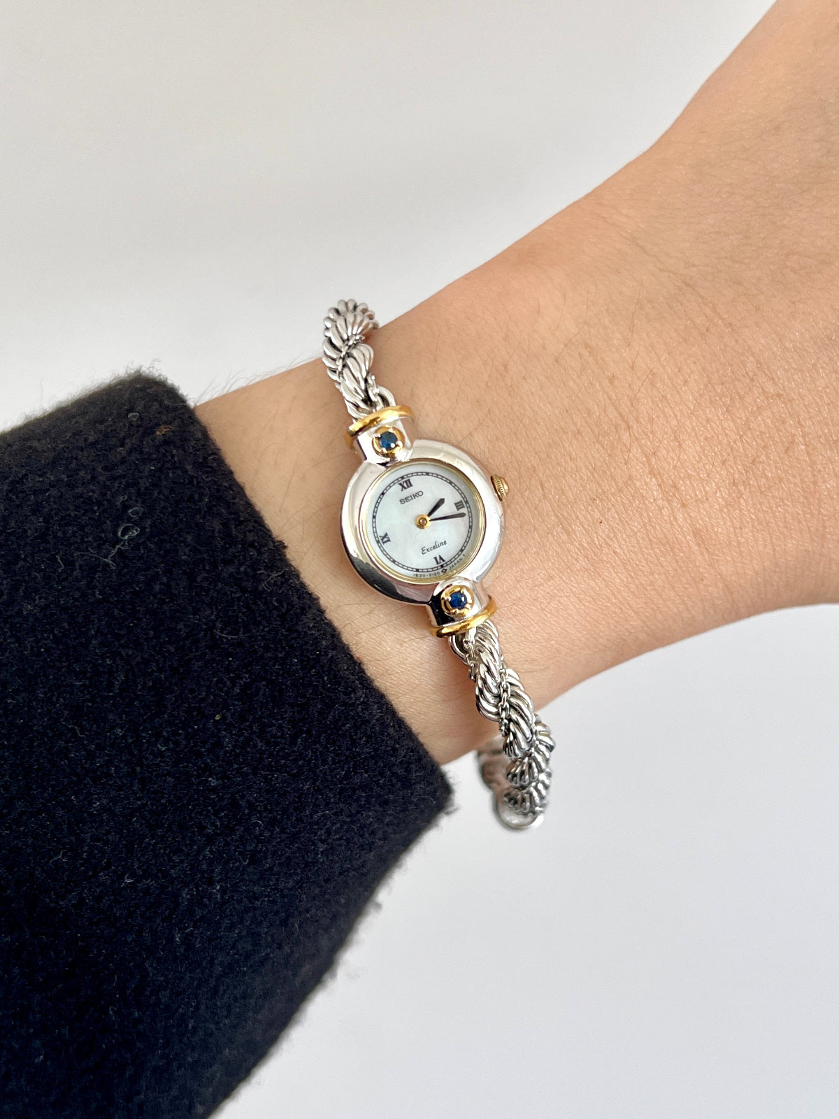 Seiko Exceline women’s watch with a white Roman numeral dial, two-tone case, and original rope bracelet.