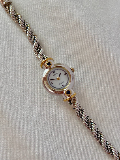 Seiko Exceline women’s watch with a white Roman numeral dial, two-tone case, and original rope bracelet.