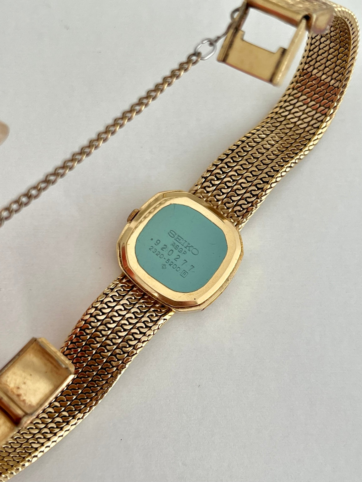 Back view of Seiko watch showing caseback marking 2320-5200, integrated chain bracelet and safety chain