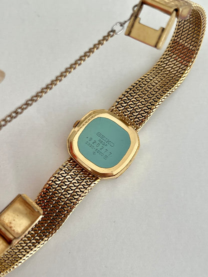 Back view of Seiko watch showing caseback marking 2320-5200, integrated chain bracelet and safety chain