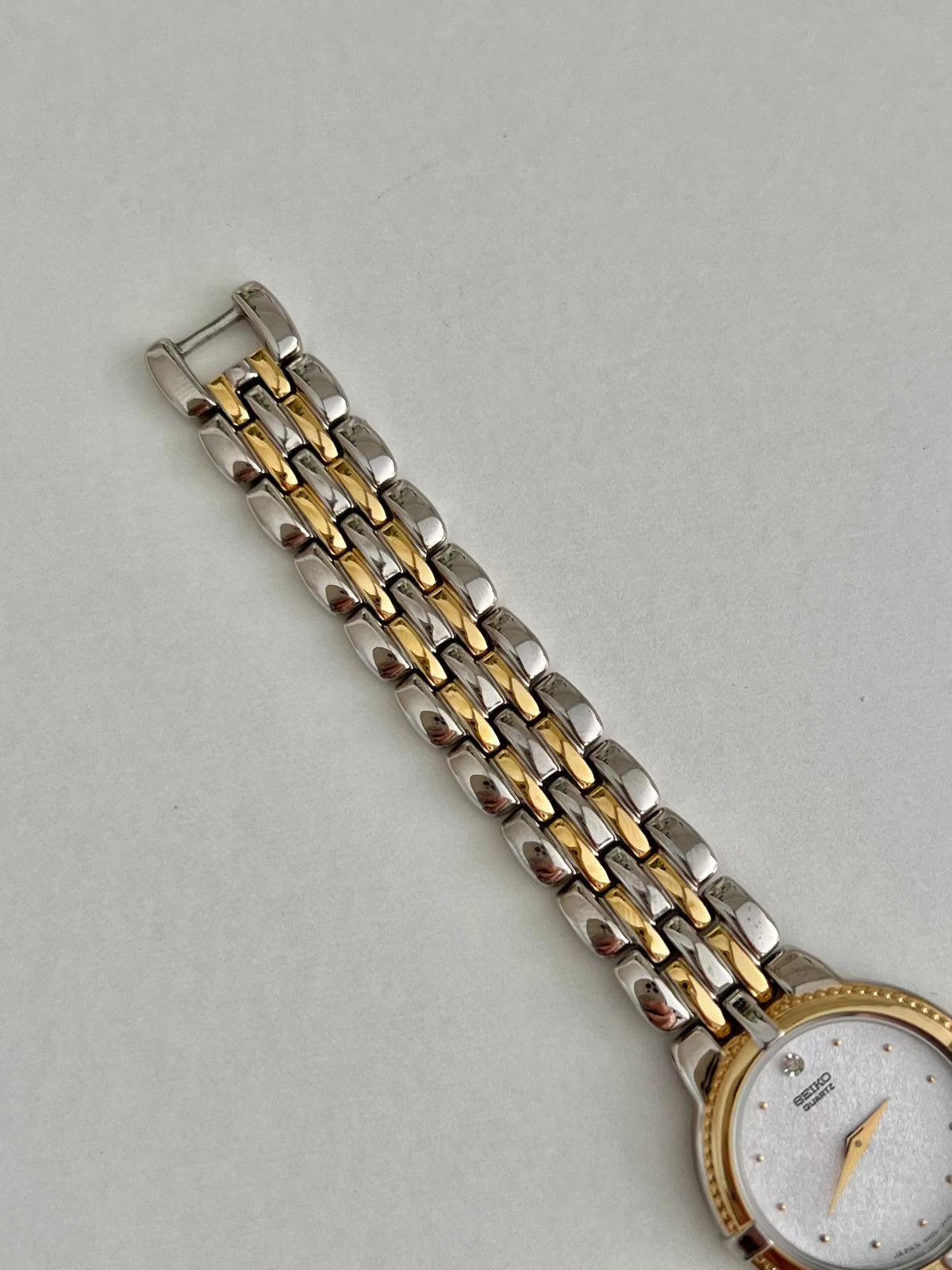 Side profile of the Seiko 4N00-0910, showing its gold-tone ribbed bezel, crown and two-tone case.