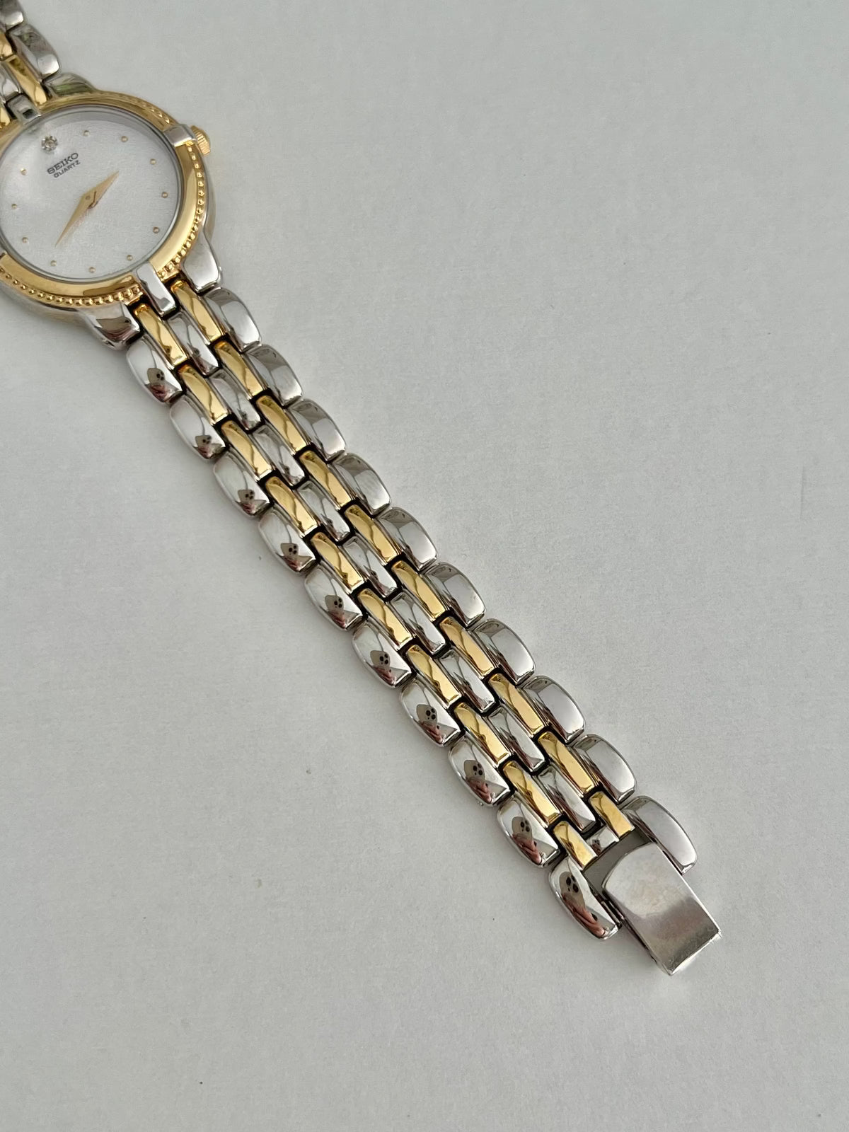Detail of the Seiko 4N00-0910 integrated bracelet with parallel gold-tone centre links and silver-tone outer links.