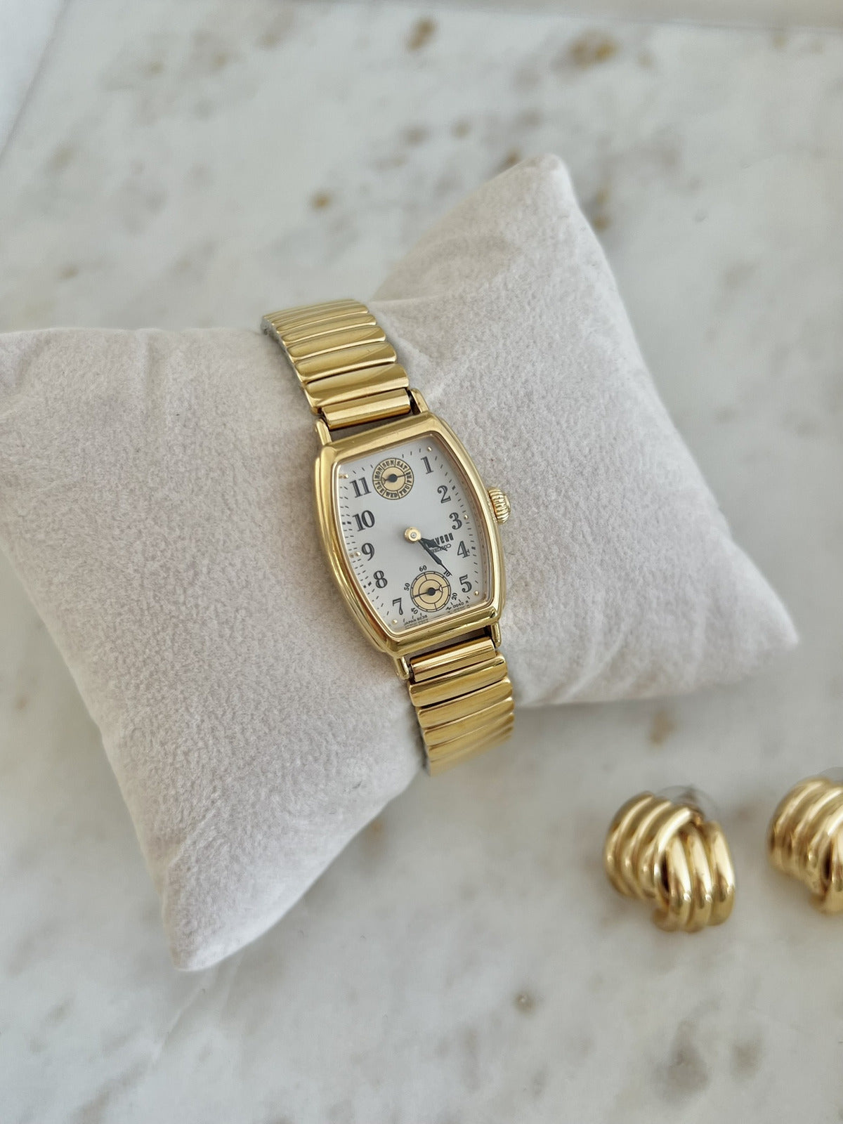 Angled view of Seiko Avenue 8E38-5000 gold-tone tonneau watch and expandable bracelet