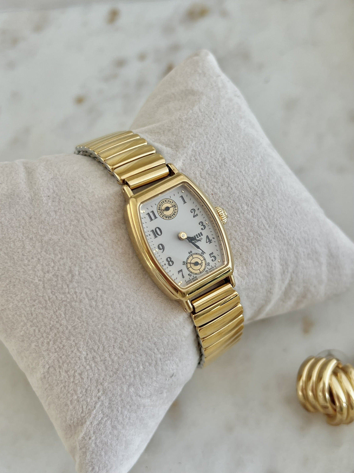 Close view of Seiko Avenue dial with Arabic numerals, day wheel at twelve and small seconds at six