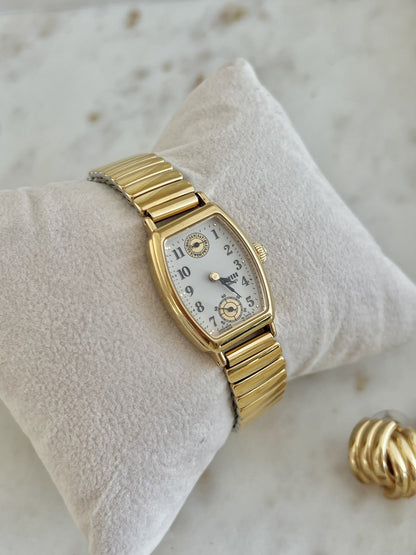 Close view of Seiko Avenue dial with Arabic numerals, day wheel at twelve and small seconds at six