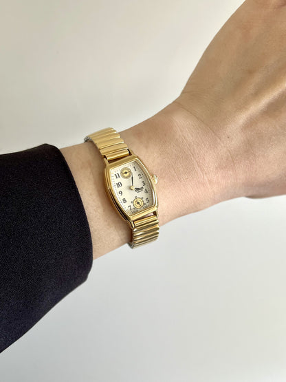 Seiko Avenue 8E38-5000 gold-tone ladies watch with day display and small seconds, worn on the wrist