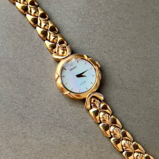 Seiko Exceline Gold Toned Woman's Watch with Radiant Mother of Pearl Dial, angled view of a vintage women's watch at Gilded Hour.