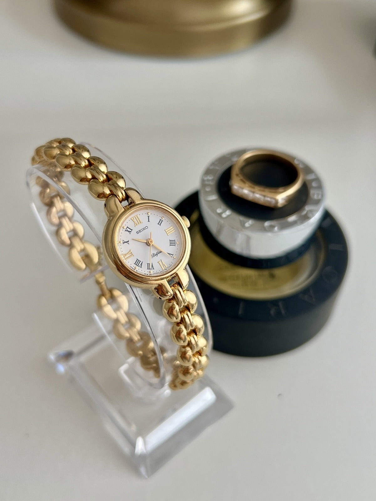 Angled view of the Seiko Belfina 4N20-0150 showing its round gold tone case and polished sculptural bracelet.