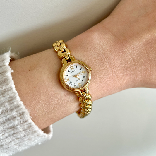 Seiko Belfina 4N21-0150 gold bracelet watch on wrist, showing white Roman numeral dial