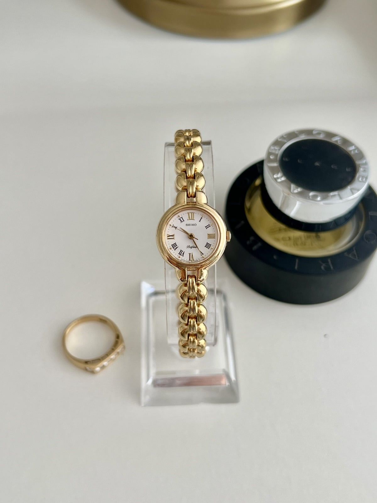 Seiko Belfina women’s watch with a white Roman numeral dial and sculpted gold tone bracelet, shown front on.