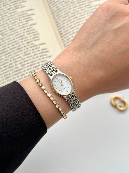 Close-up of the Seiko Belfina white dial with gold markers and Roman numerals.