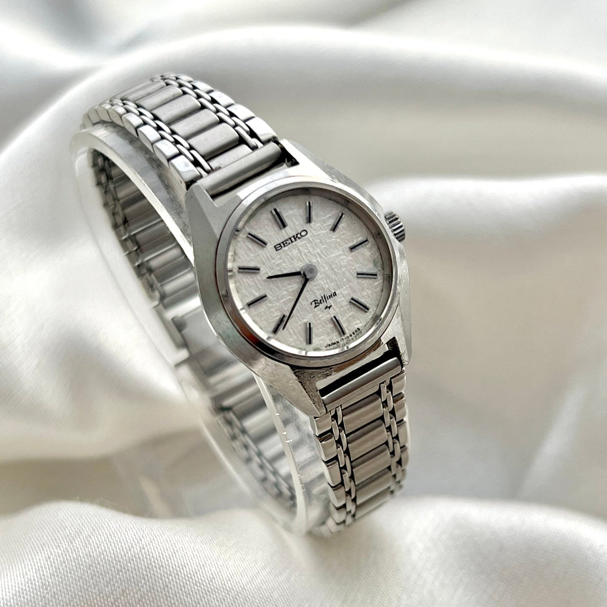 Seiko Bellina women’s bracelet watch with silver woven textured dial, polished stainless steel case, slim baton markers and rice bead style bracelet, elegant Japanese dress watch photographed by The Gilded Hour