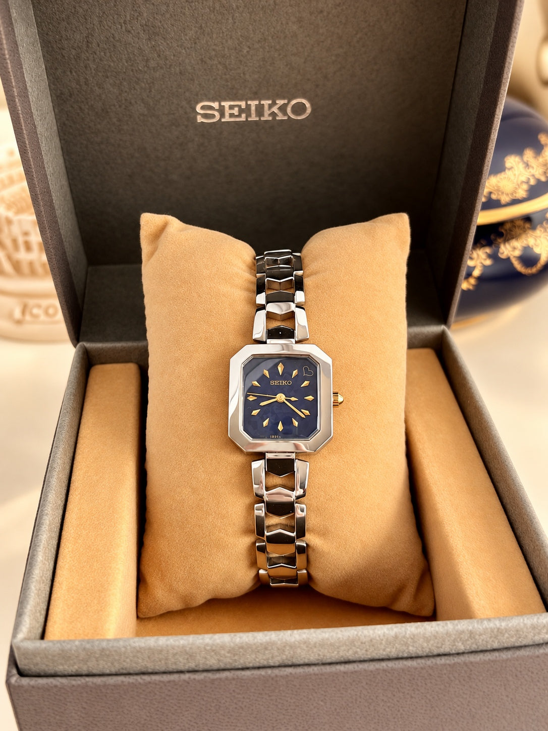 Seiko women’s watch in its original box with a dark blue dial, gold markers and a polished silver open link bracelet
