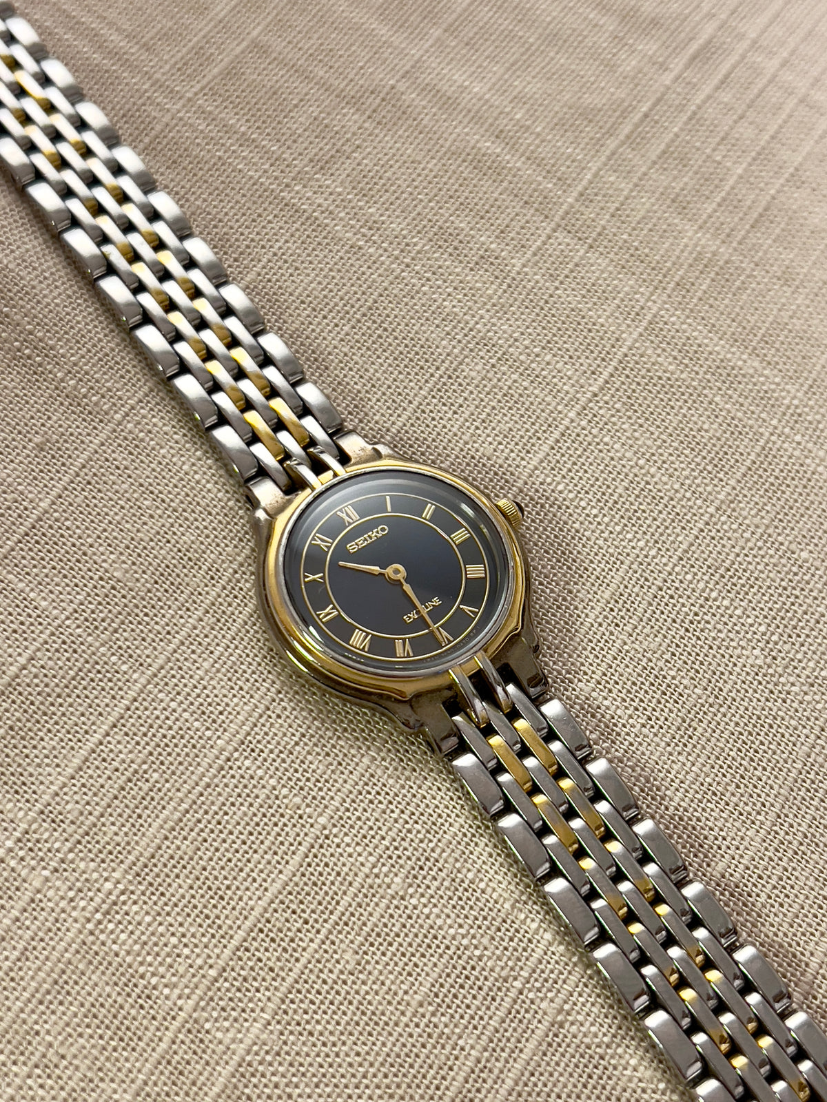 Seiko Exceline Two-Tone Woman’s Watch – Deep Blue & Gold Roman Dial — close view of the navy dial and gold-tone bezel.