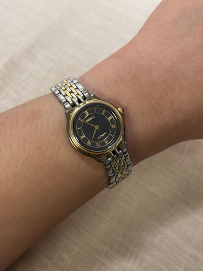 Seiko Exceline Two-Tone Woman’s Watch – Deep Blue & Gold Roman Dial — the two-tone bracelet and watch case shown at an angle.