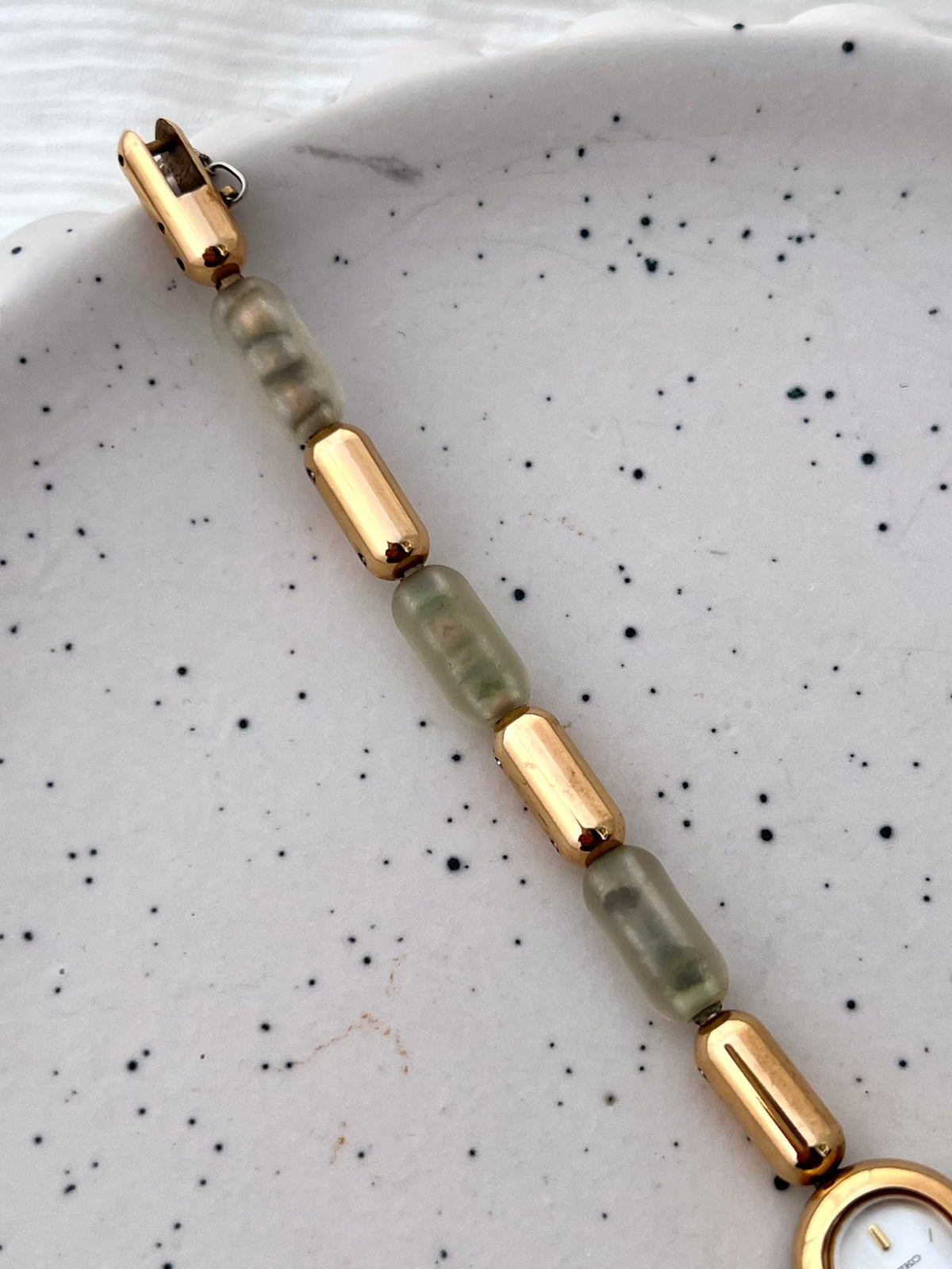 Wrist view of the Seiko capsule-shaped watch and gold-tone resin-segment bracelet.