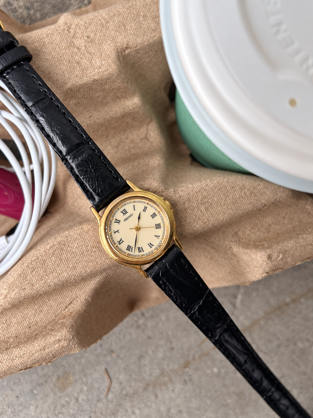 Close view of the Seiko cream Roman dial, fine minute track, gold tone bezel and straight lugs.