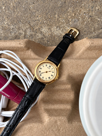 Full view of the Seiko cream Roman dial watch and textured black leather strap.