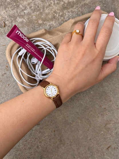 Full wrist view of the Seiko Exceline gold tone Roman dial watch and brown leather strap.