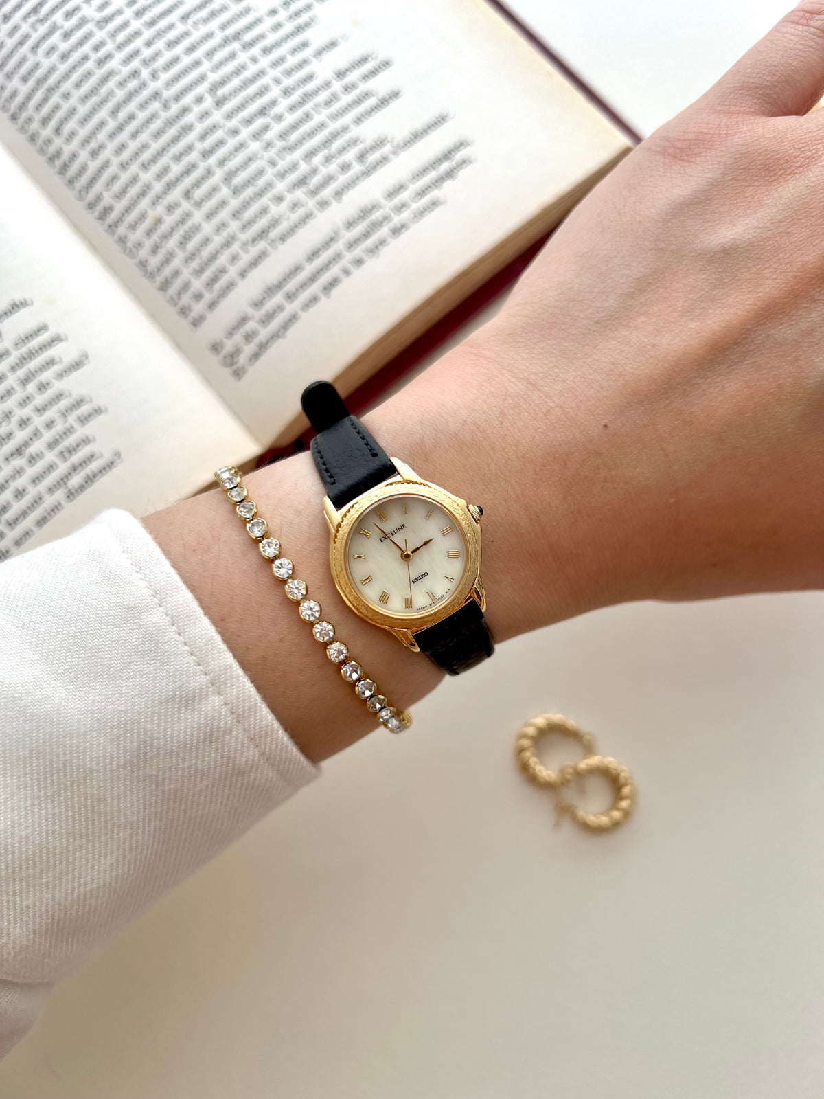 Front view of the Seiko Exceline gold watch with mother-of-pearl dial and Roman numerals.
