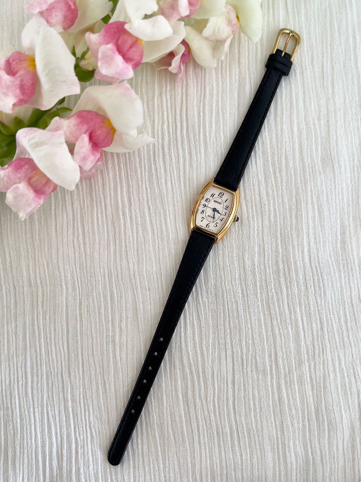 Seiko Exceline Gold Tonneau Women’s Watch with Arabic Dial — full watch and black leather strap.