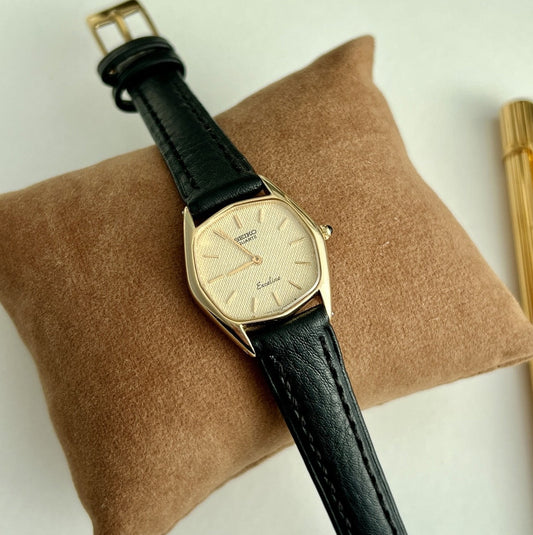 Seiko Exceline women’s watch with a champagne linen dial, gold filled tonneau case and aftermarket black leather strap.