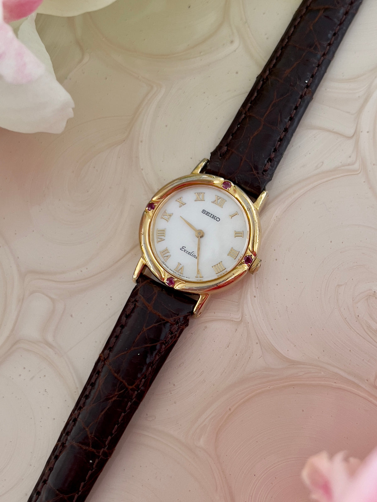Seiko Exceline Mother of Pearl Women’s Watch with Ruby Accents — close view of mother of pearl dial.
