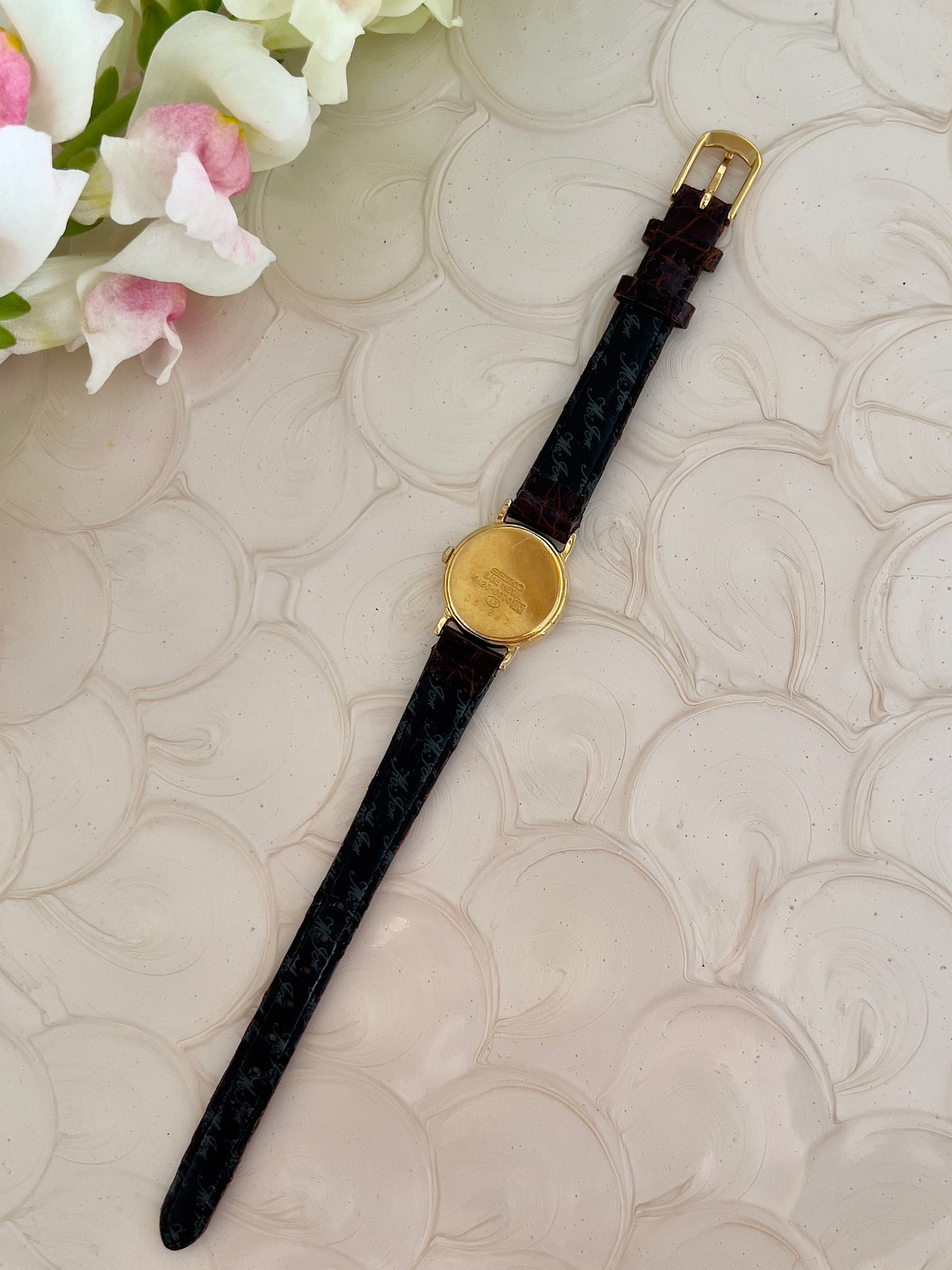 Seiko Exceline Mother of Pearl Women’s Watch with Ruby Accents — caseback and inside of brown strap.