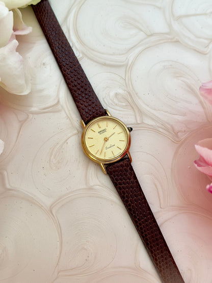 Angled view of the Seiko Exceline gold-tone watch with champagne dial.