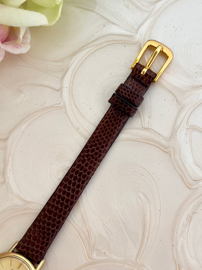 Detail of the champagne stardust dial and gold-tone markers.