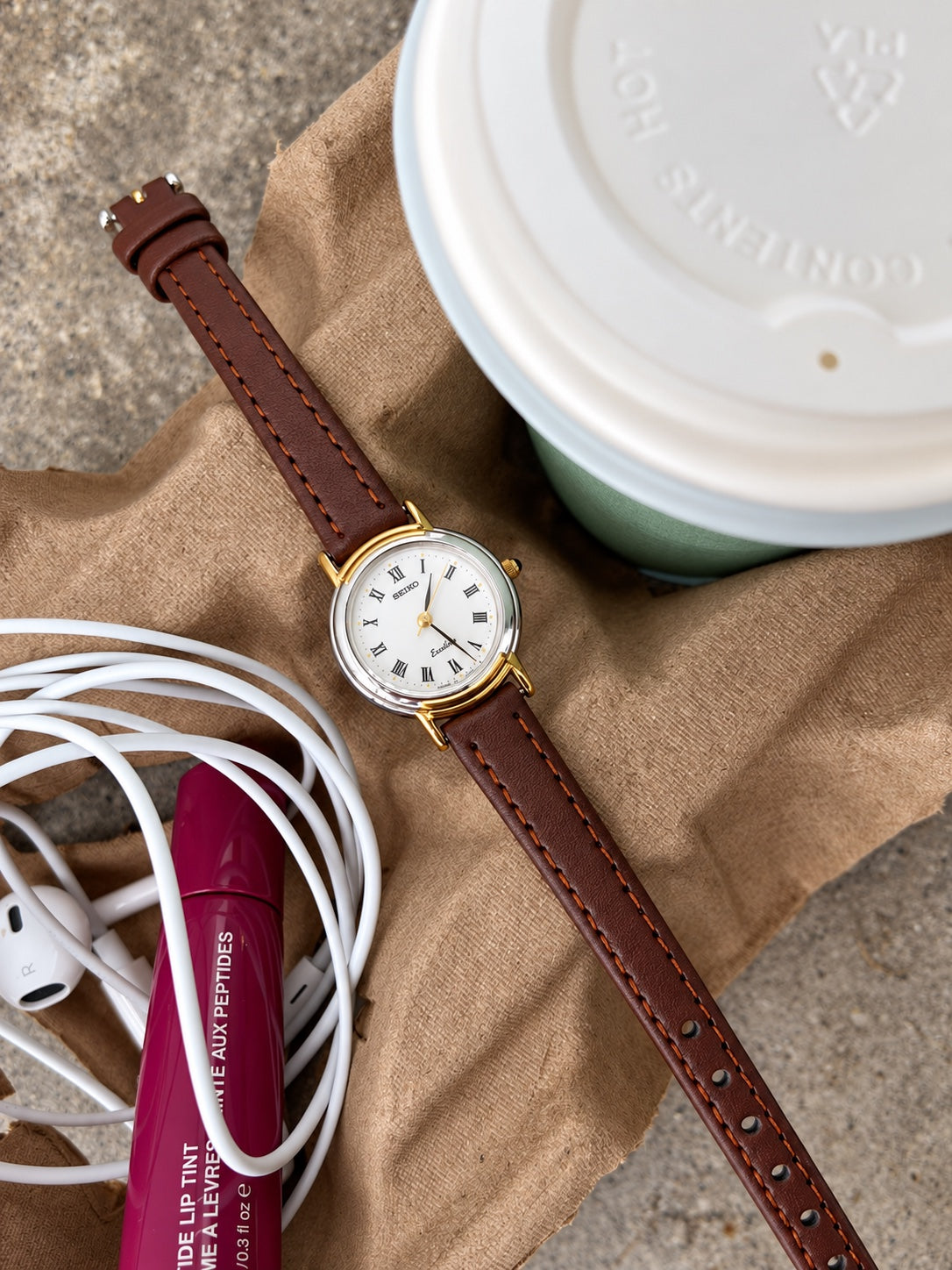 Full view of the Seiko Exceline two tone round watch with a brown leather strap and contrast stitching.