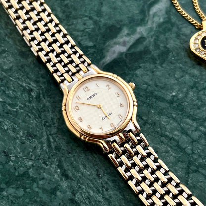 Front view of the Seiko Exceline two-tone watch with champagne guilloché dial.