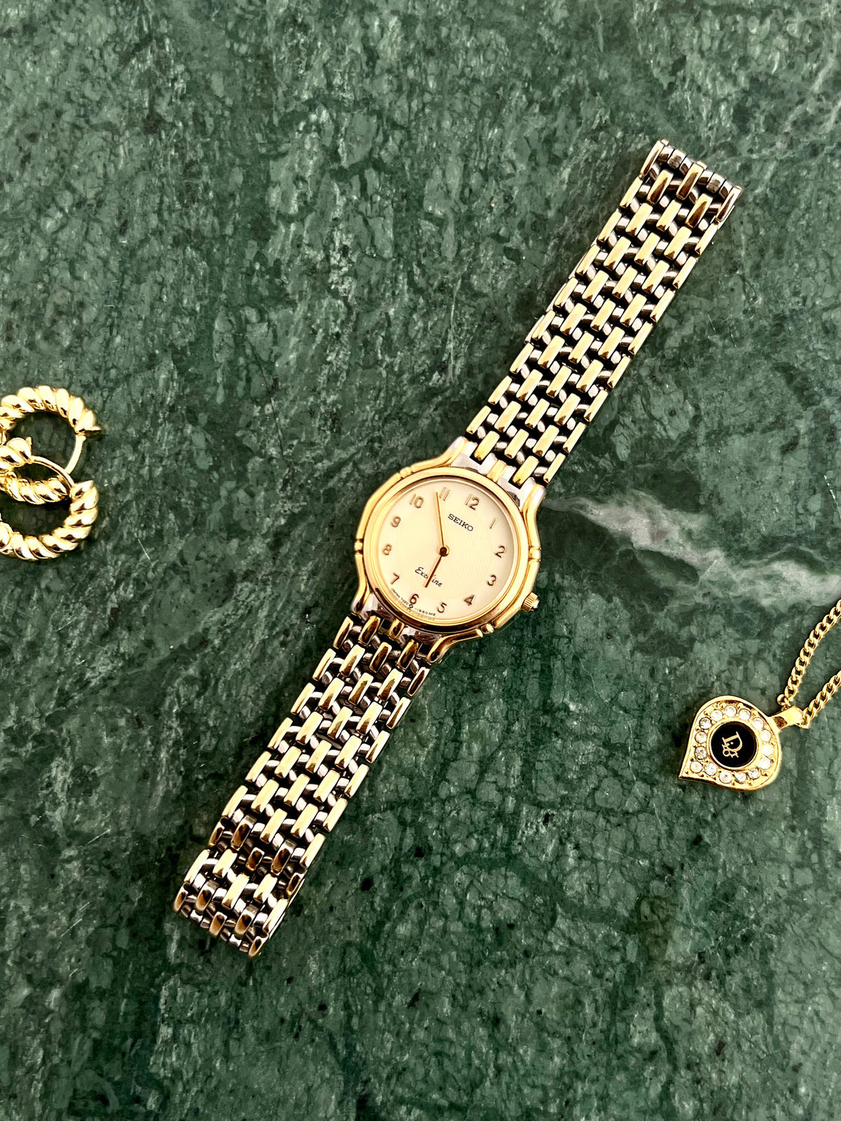 Seiko Exceline two-tone watch shown on a wrist.
