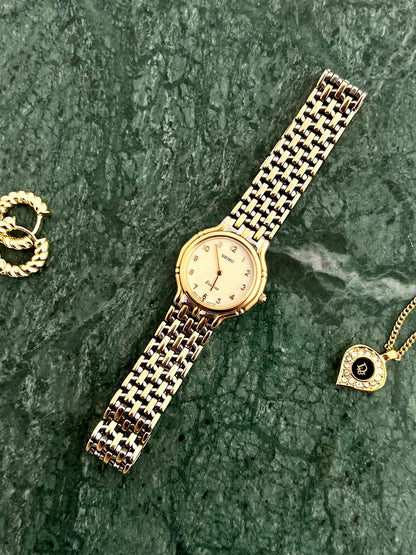 Seiko Exceline two-tone watch shown on a wrist.