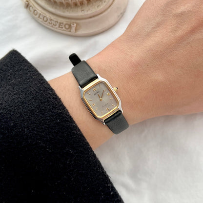 Seiko Exceline women’s watch worn on wrist featuring a two tone rectangular case, textured silver dial, Roman hour markers and black leather strap