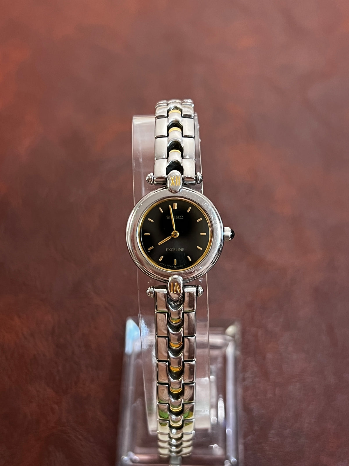 Seiko Exceline black dial watch with gold hands and a decorative two tone bracelet, product photograph 2.