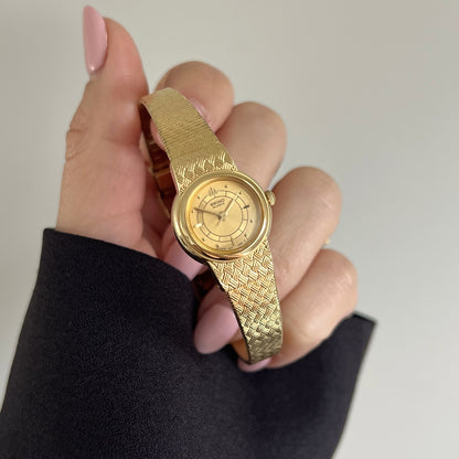 Seiko Galaxy champagne dial with segmented inner ring, dot and baton markers and gold tone basket weave bracelet.