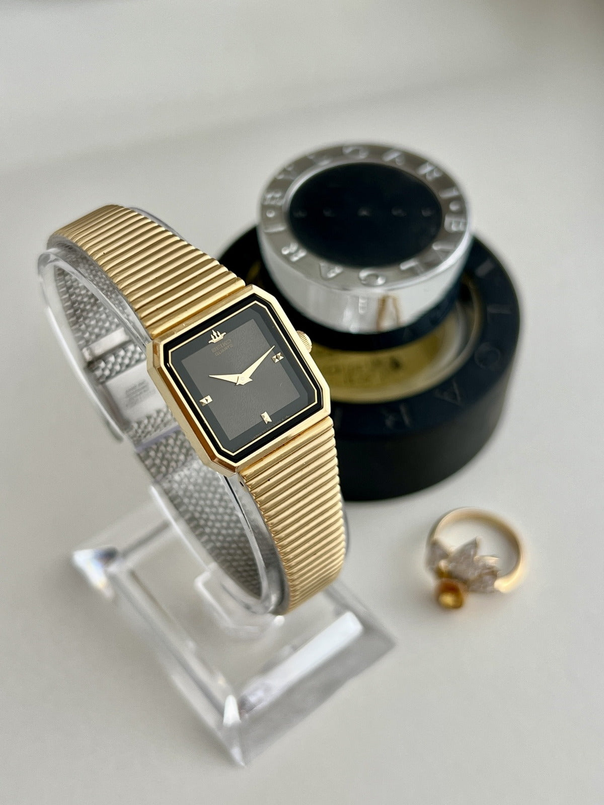 Angled view of the 1985 Seiko Galaxy gold tone women’s watch with a black textured panel dial and flexible bracelet.