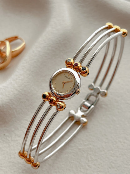 Seiko Tissé two-tone bangle watch with a champagne dial and ruby, sapphire and clear crystal accents; product image 4.