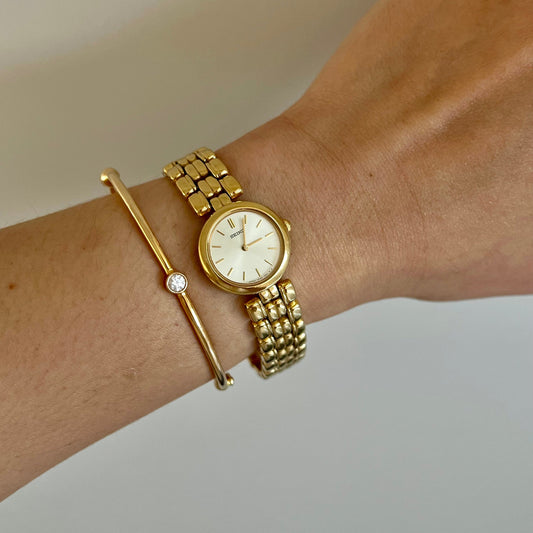 Seiko gold bracelet women’s watch with cream dial and round case on wrist